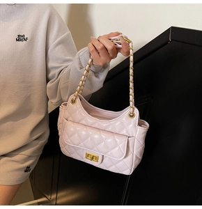 Detailed view of pink quilted handbag with gold chain strap and metal turn-lock closure