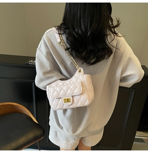Dettaglio della borsa baguette in pelle trapuntata rosa chiaro con catena dorata