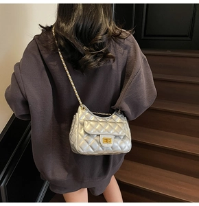 Silver quilted shoulder bag with gold chain strap and turn-lock on a model