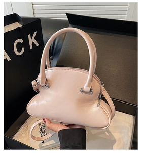 Detail of light pink toast-shaped shell bag with silver buckles and adjustable strap