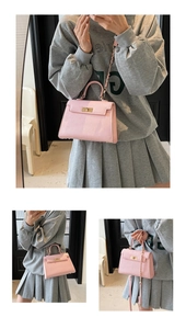 Detailed view of the pink trapezoid handbag with gold twist lock and chain strap