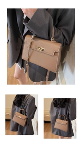 Detail of brown litchi grain leather handbag with gold metal twist lock and chain strap