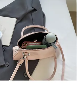 Pink shell bag showing spacious interior with umbrella, phone, and wallet capacity
