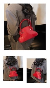 Detail of glossy red toast-shaped shell bag with smooth patent leather and shoulder strap