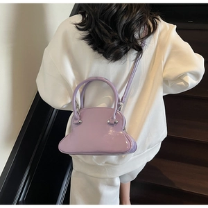 Detail of light purple glossy patent leather handbag with shell silhouette and strap
