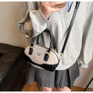 Canvas bowling bag with leather trim shown on model for a stylish crossbody look