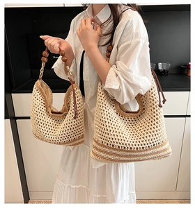 Detail of hollow woven straw tote bag with brown beads and neutral fabric lining