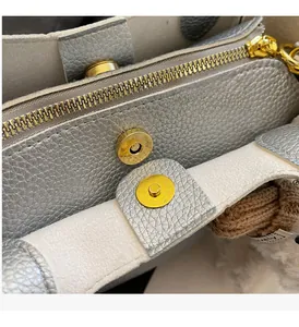 Detail of lychee pattern leather bag showing gold zipper and magnetic closure