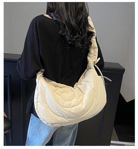 Detail view of the quilted cream hobo bag with unique spiral stitching and soft texture