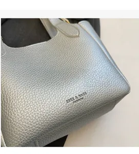 Close-up of silver lychee texture leather handbag featuring refined stitching and metal finish