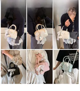 Vue détaillée du sac à main à nœud avec pendentif cœur en plusieurs positions de port
