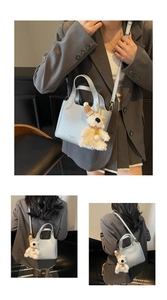 Detail of light blue lychee pattern bucket bag with cute plush bear charm accessory