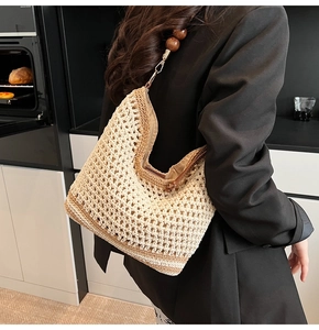 Detailed shoulder view of a hollow-out woven hobo bag with vintage wooden beads
