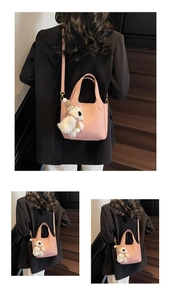 Detail view of pink litchi pattern bucket bag with bear pendant and gold hardware