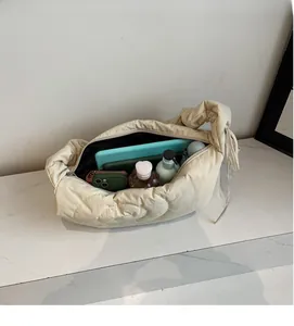 Interior view of spacious beige quilted nylon bag showing storage for tablet and makeup