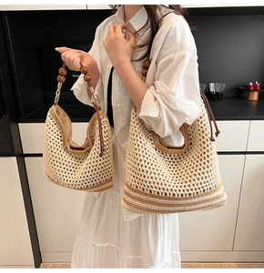 Detail of woven tote bag with wooden bead handle and neutral striped pattern