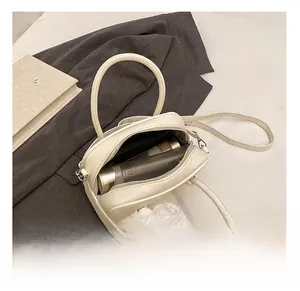 Vue détaillée de l'intérieur spacieux d'un sac à main en cuir blanc avec des accessoires