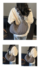Detailed view of dark grey quilted nylon crescent bag with ruched ruffled shoulder strap