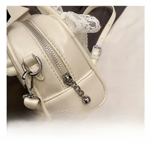 Vue macro détaillée des ferrures argentées et de la dentelle sur le sac crème