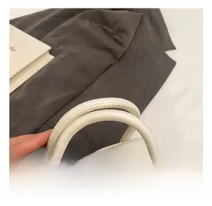 Détail du sac polochon en cuir blanc montrant les coutures renforcées et la fermeture éclair
