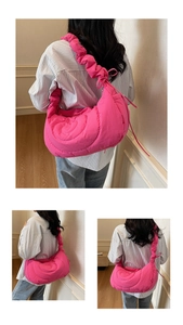 Detail of rose pink quilted bubble bag featuring spiral stitching and ruffled shoulder strap