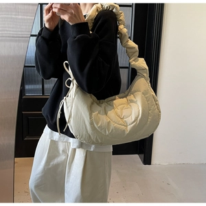 Detail of cream pleated shoulder bag with heart-shaped quilting and cloud strap