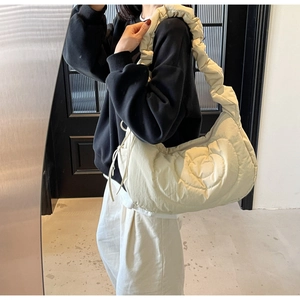Close-up of cream heart quilted shoulder bag featuring stylish ruched strap detail