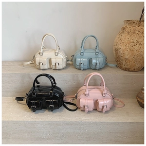 Mini bowling bags in four pastel colors arranged on stone steps with a vintage vase