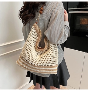 Detail of woven tote bag with hollow crochet texture and wooden bead strap accents