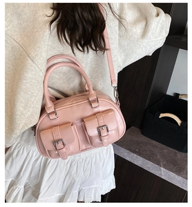 Pink glossy bowling bag shown on a model with adjustable strap and twin handles
