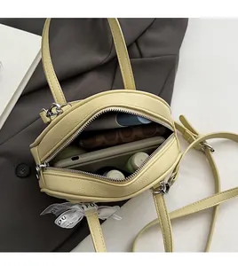 Interior view showing the capacity of this small yellow leather bag with silk ribbon