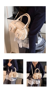 Detail of cream bowling bag featuring dual front pockets and matte leather texture