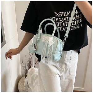 Light blue bowling handbag for women with lace bow and heart pendant. Fashionable crossbody bag.