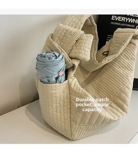 Detail of quilted beige shoulder bag featuring a side pocket for umbrella storage