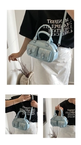 Detail of light blue patent leather bowling bag with twin buckle pockets and strap