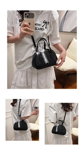 Detail of black bowling bag with lychee texture and decorative ribbon on handle