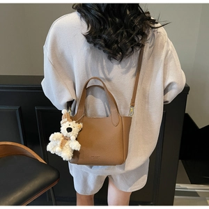 Brown lychee texture leather bucket bag with cute plush bear charm and adjustable strap