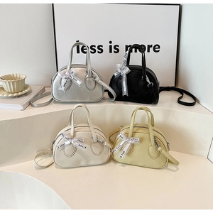 Collection of four textured leather bowling bags in silver, black, beige, and soft yellow