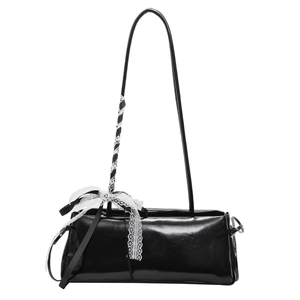 Minimalistische schwarze glänzende Baguette-Tasche mit weißer Spitzenschleife am Trageriemen