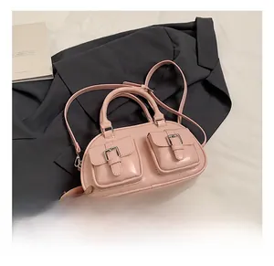 Detailed view of pink bowling bag with metallic buckle pockets on grey suit