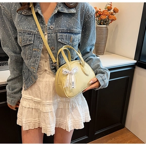 Detail of yellow lychee leather handbag with a Just For You decorative ribbon bow