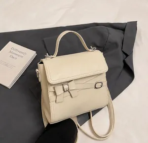 Gros plan du sac à main en cuir blanc crème avec nœud élégant et boucle en métal