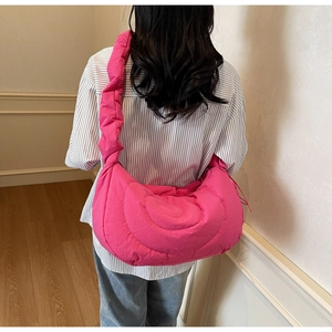 Detailed back view of a bright rose pink quilted dumpling shoulder bag worn by model