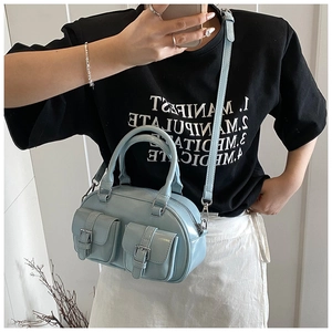 Detail of light blue Boston bag featuring cargo-style pockets and detachable strap