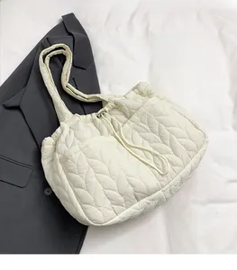 Detail of leaf-quilted tote bag in cream white with lightweight fabric and shoulder strap
