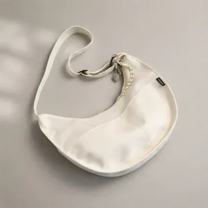 Detailed shot of white lightweight nylon crescent bag with adjustable strap and side label