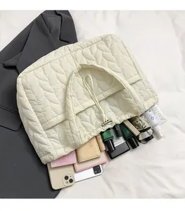 Spacious off-white quilted tote bag showing interior storage for phone and umbrella