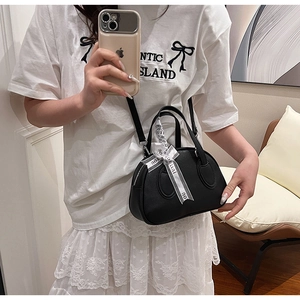 Mirror selfie showing a black textured bowling bag with decorative Just For You ribbon