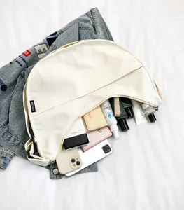 Internal view of beige dumpling bag showing storage for phone and accessories