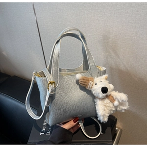 Silver lychee grain leather mini bucket bag with a plush puppy charm and gold hardware